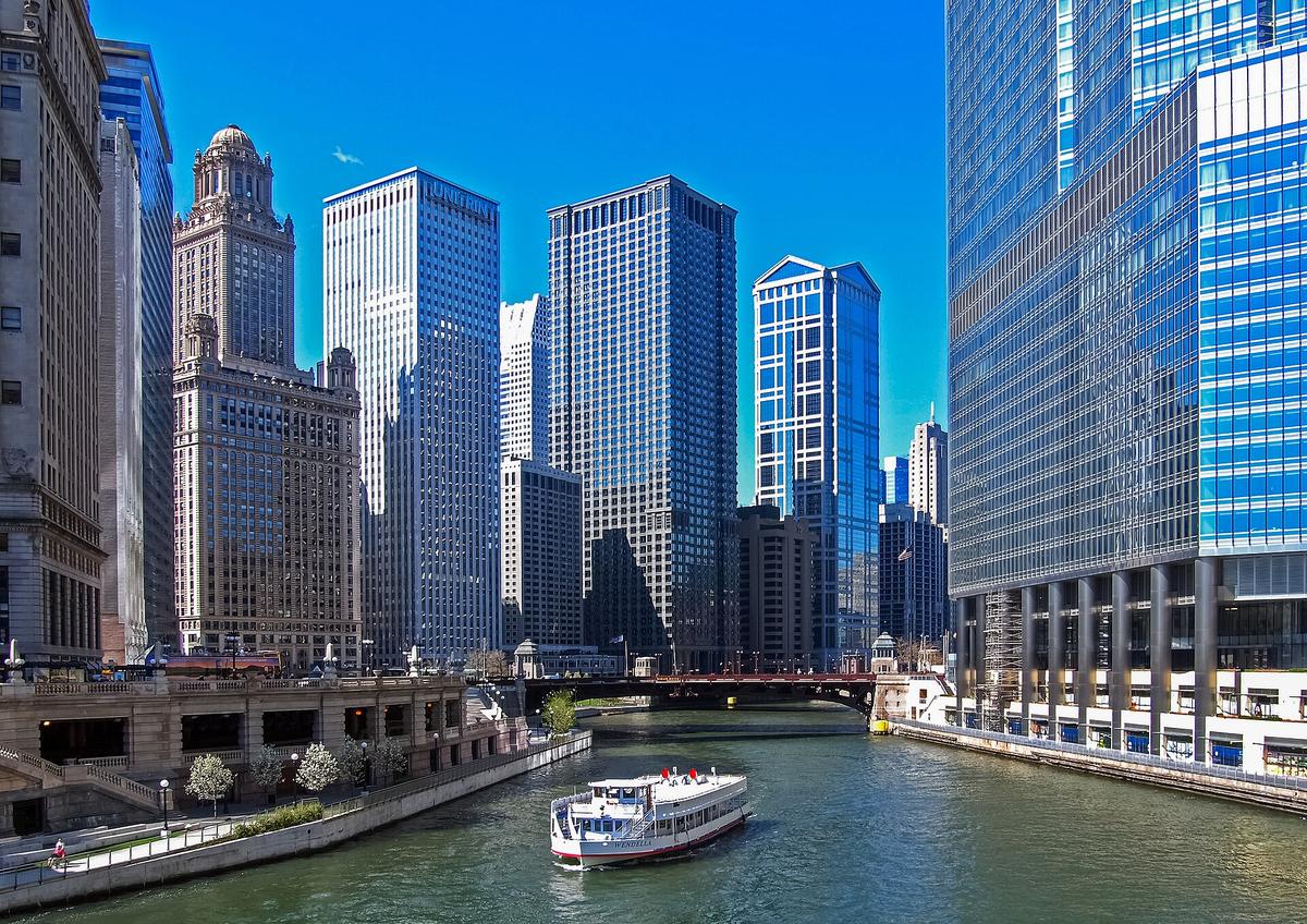 A tour boat on the Chicago River below downtown skyscrapers