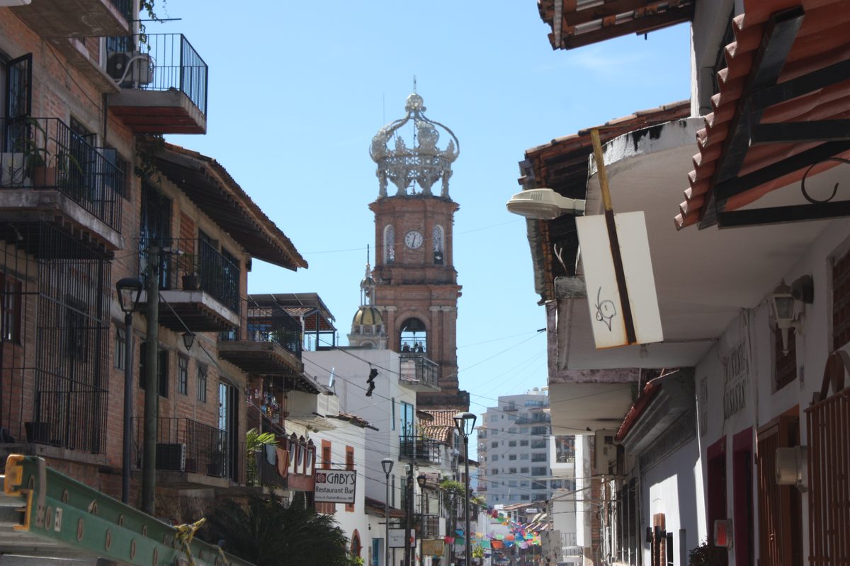 The crowned tower of the Church of Our Lady of Guadalupe above a street in Puerto Vallarta